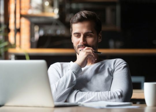 Thoughtful businessman think of online project looking at laptop at workplace, dreamy professional consider solution sit at work desk with computer, student search new idea inspiration in office cafe